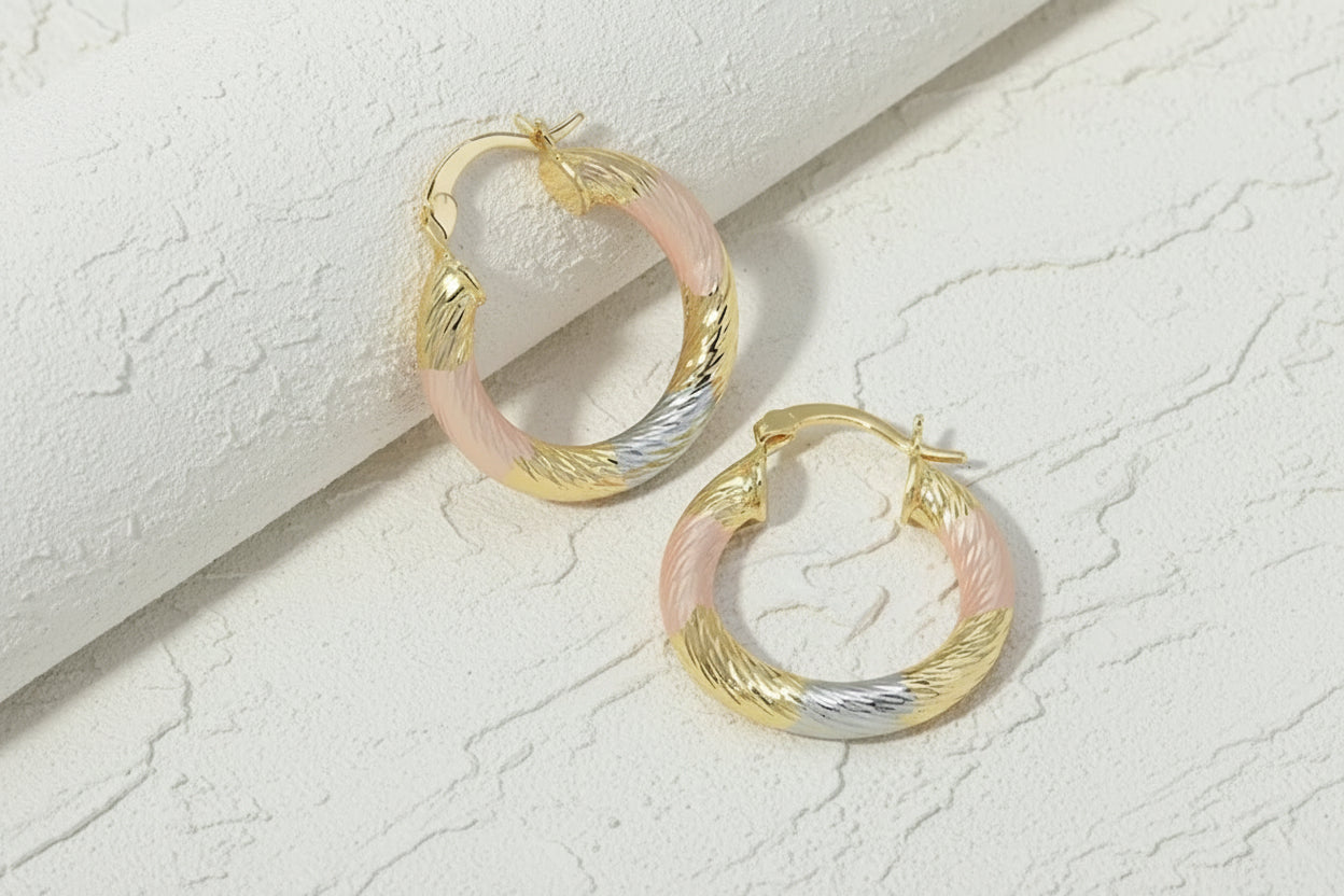 Pair of gold hoop earrings with a gradient finish on a white background.
