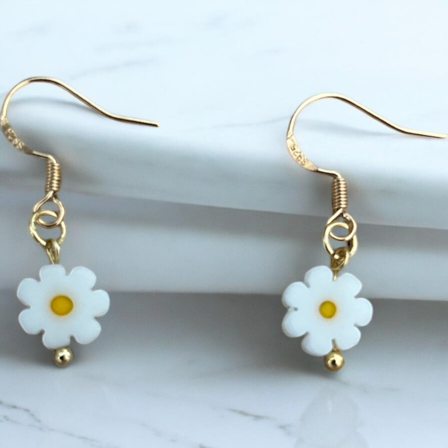 A pair of charming mini daisy earrings with gold plated hooks.