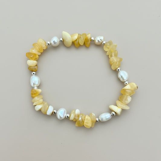 A honey yellow calcite crystal chip, fresh water pearl, and beaded bracelet with silver beads and a silver clasp.