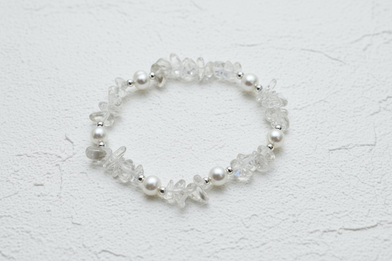 A bracelet made of clear quartz crystal chips and fresh water pearls with silver-coloured beads.