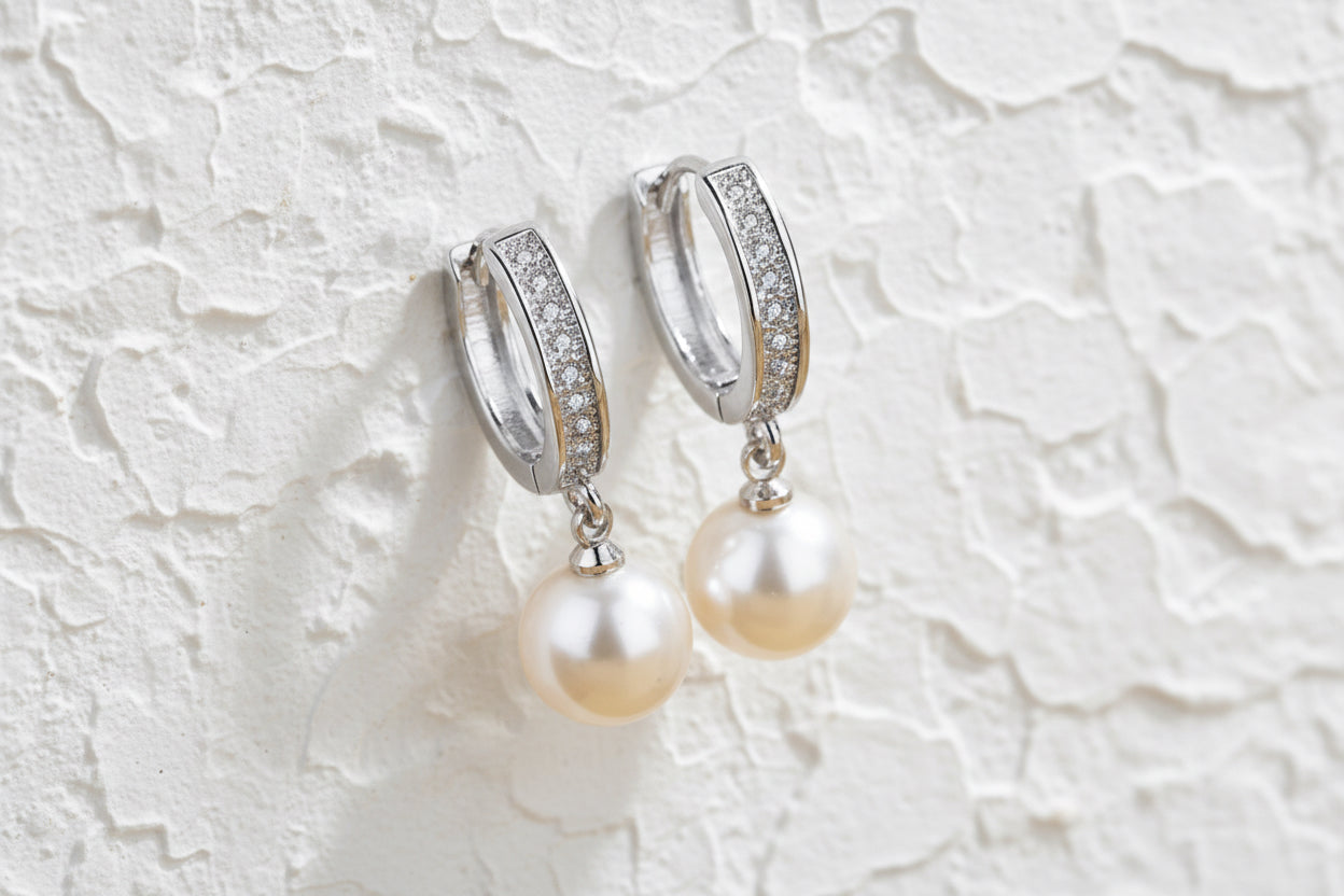 Silver huggie earrings with diamantè style finish and drop round white pearls.