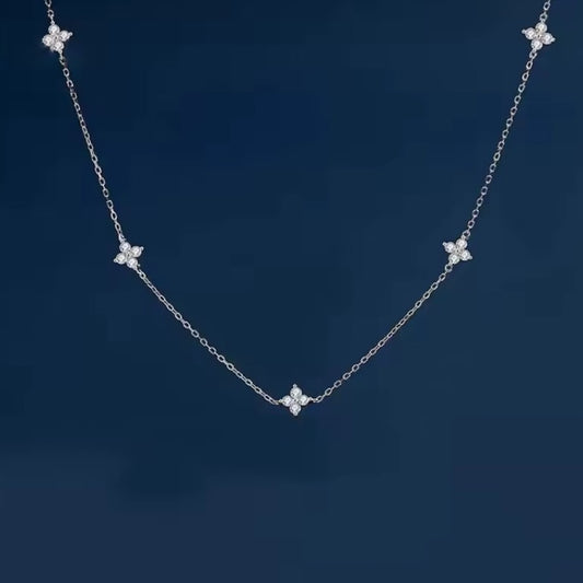 Silver necklace necklace with dainty crystal clovers on a dark blue background