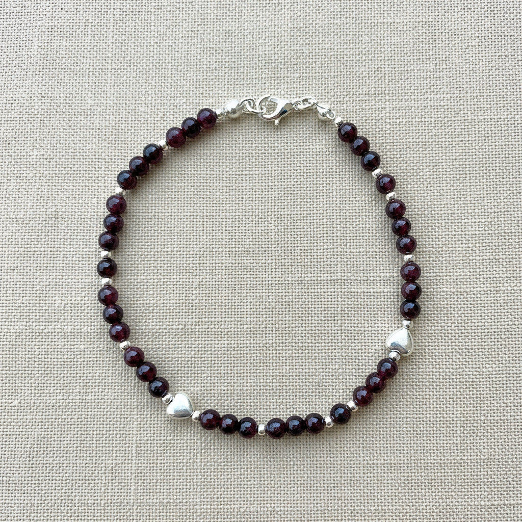 A deep red garnet and silver beaded bracelet.