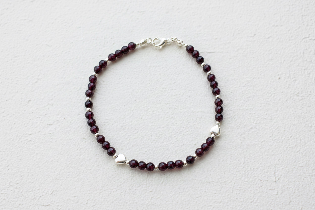 A deep red garnet and silver beaded bracelet.