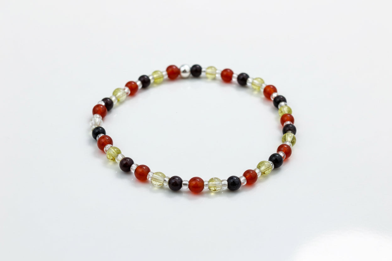 Beaded bracelet with multicoloured beads on a textured surface.