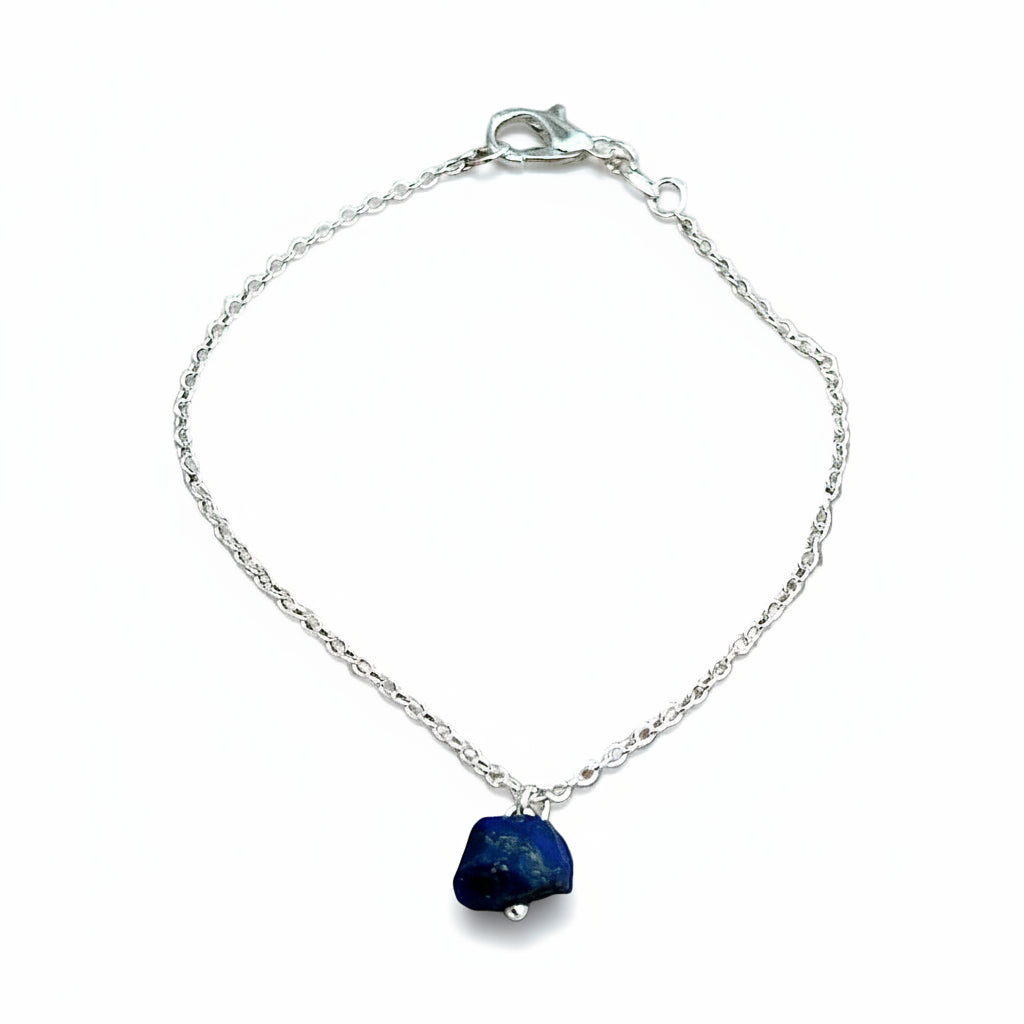 Silver bracelet with a blue stone pendant on a white background.