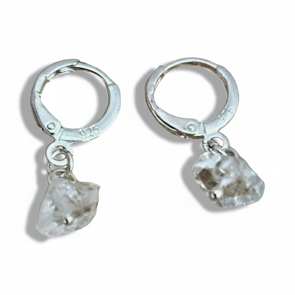 A pair of sterling silver earrings with clear quartz crystal accents, displayed against a white background.
