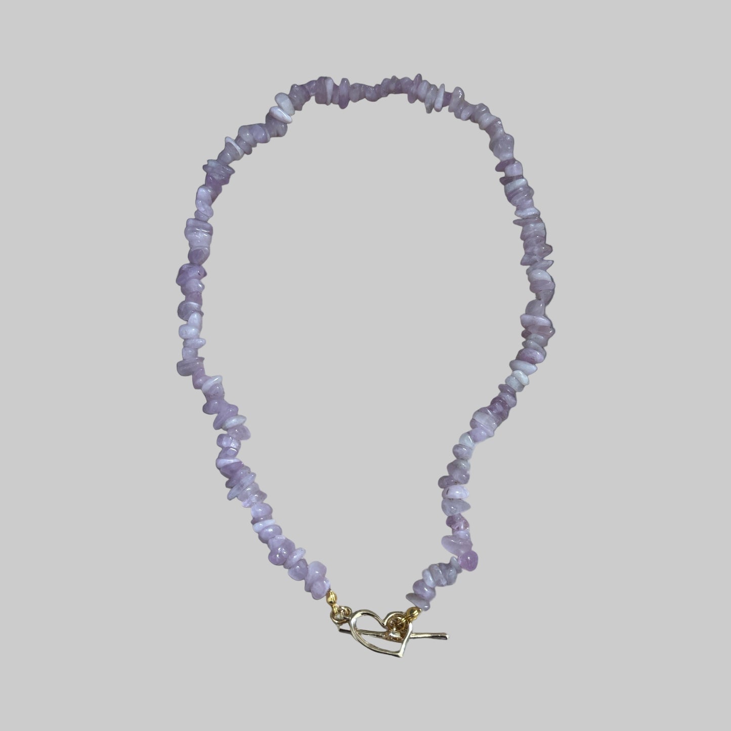 A lilac purple Kunzite crystal chip necklace with a gold-colored clasp .