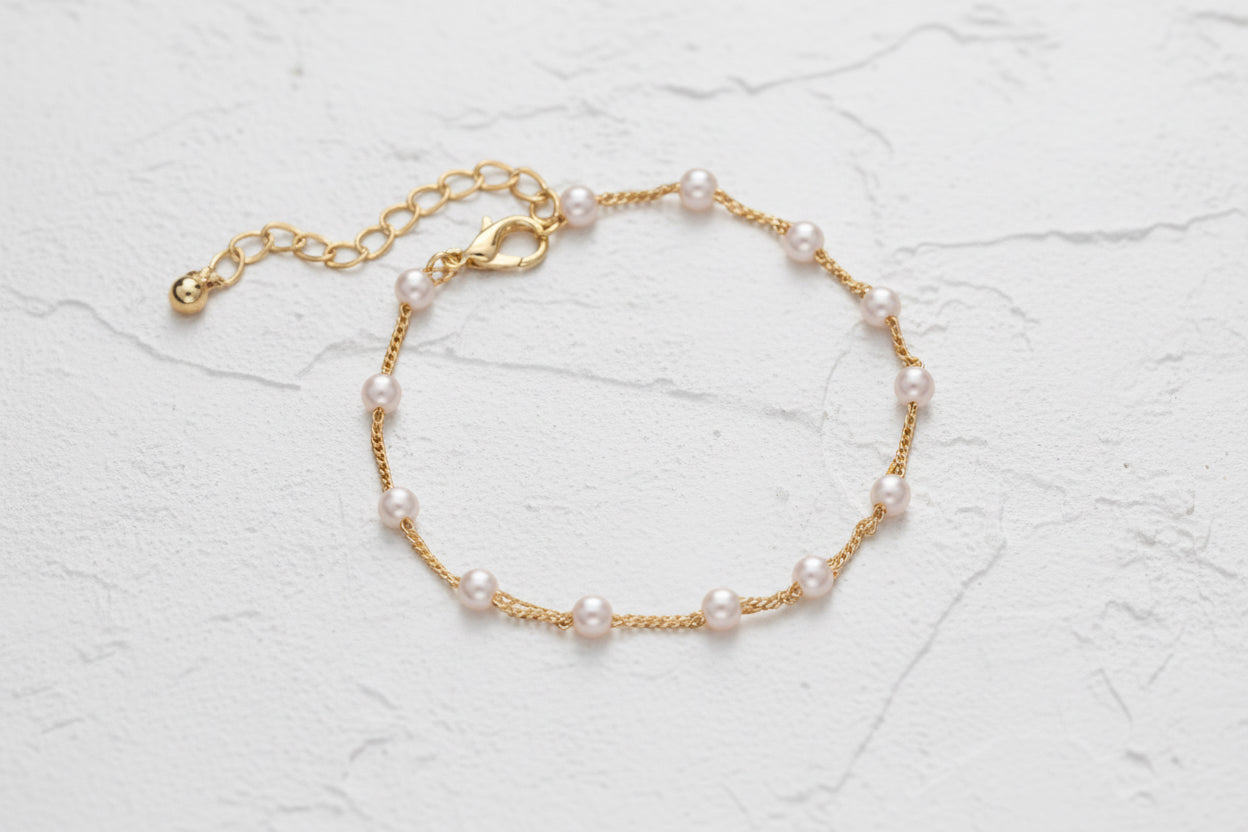 Gold bracelet with pearl beads.
