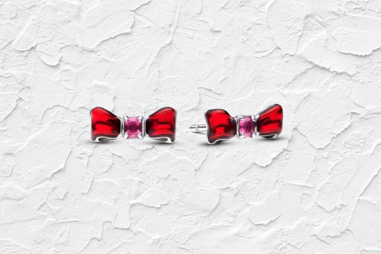 Red bow-shaped earrings with pink gemstones.