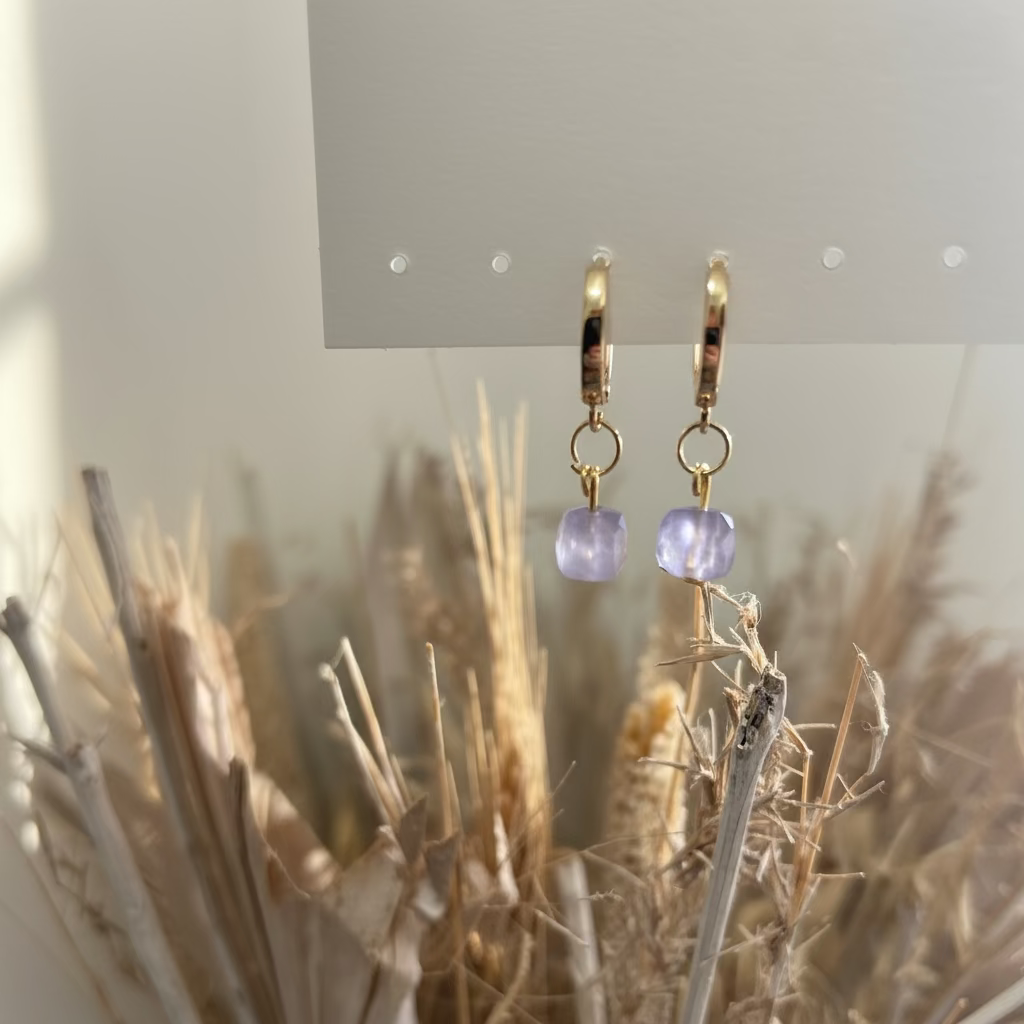 Gold earrings with lilac coloured beads.