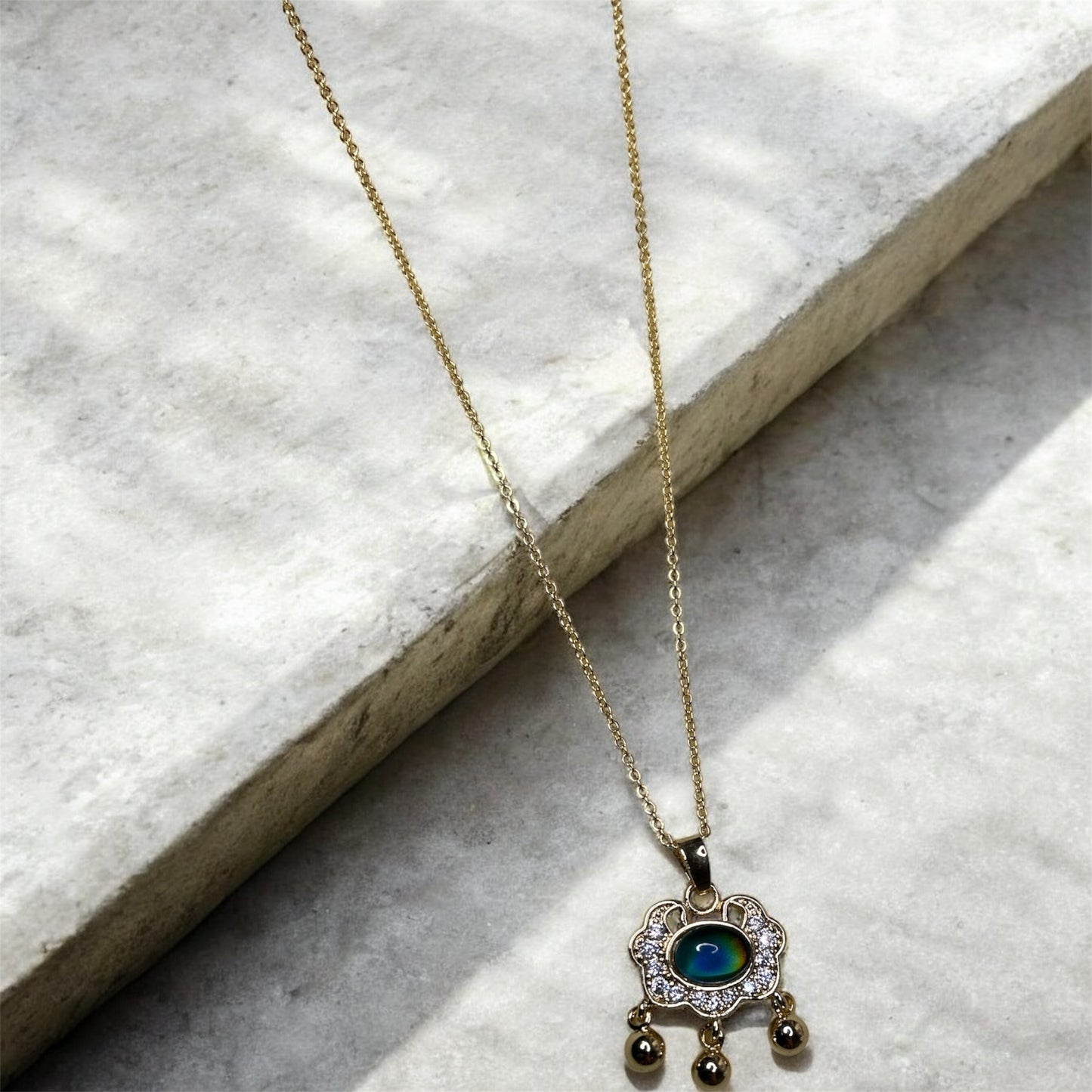 Gold necklace with colour change pendant