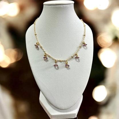 Necklace with pink beads on a white mannequin bust against a blurred background.