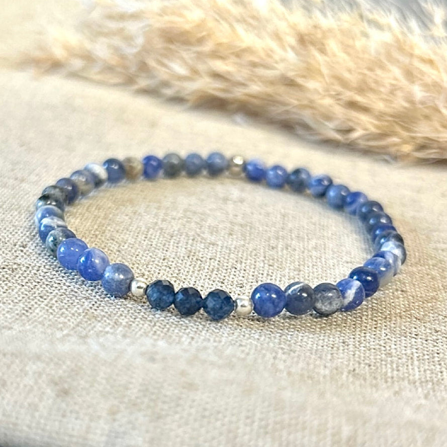 Blue beaded bracelet on a textured surface.