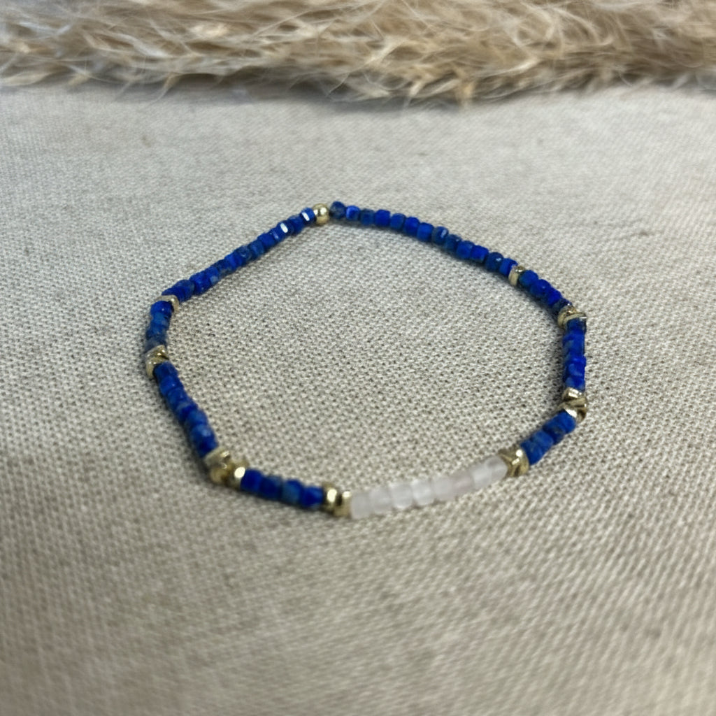 Beaded bracelet with blue and gold beads on a textured fabric background