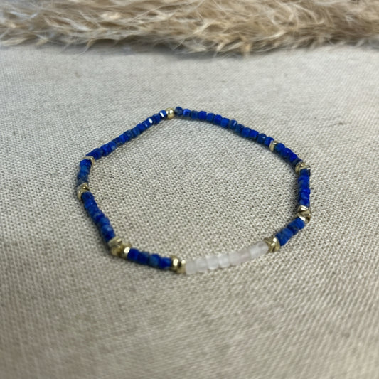 Beaded bracelet with blue and gold beads on a textured fabric background