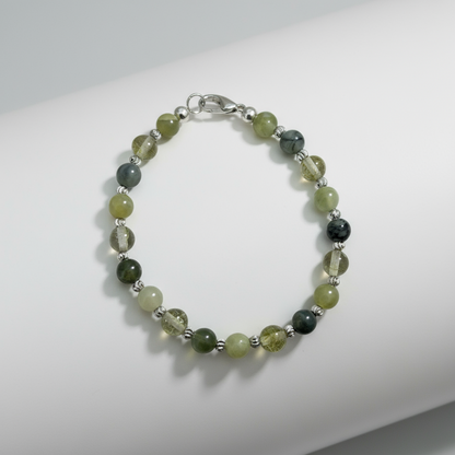 Beaded bracelet with green and black beads on a white background.
