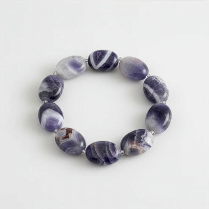 Purple amethyst beaded bracelet on a light grey background.