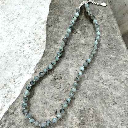 Beaded necklace on a stone surface.