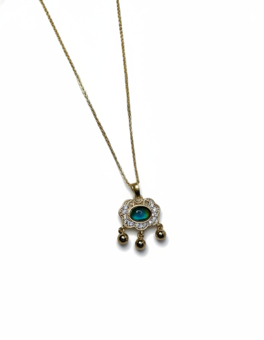 Colour changing gem pendant necklace on a gold coloured chain.