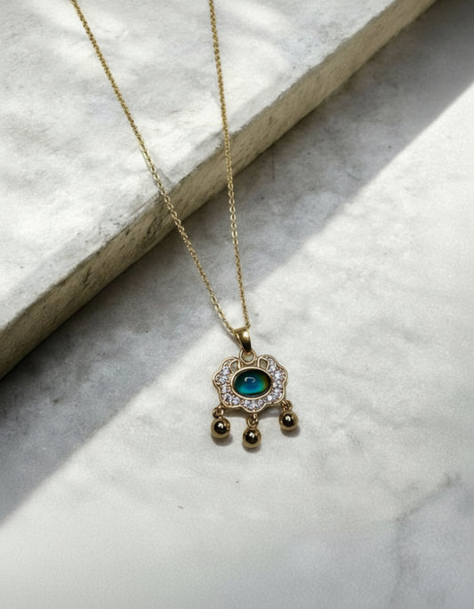 Colour changing gem pendant necklace on a gold coloured chain.
