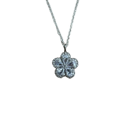 Flower shaped crystal pendant on a silver chain against a light background