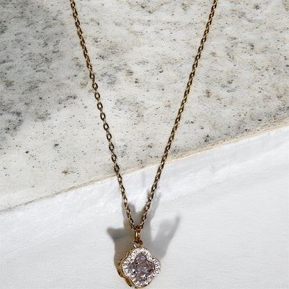 Gold necklace with a diamanté and clear clover pendant.