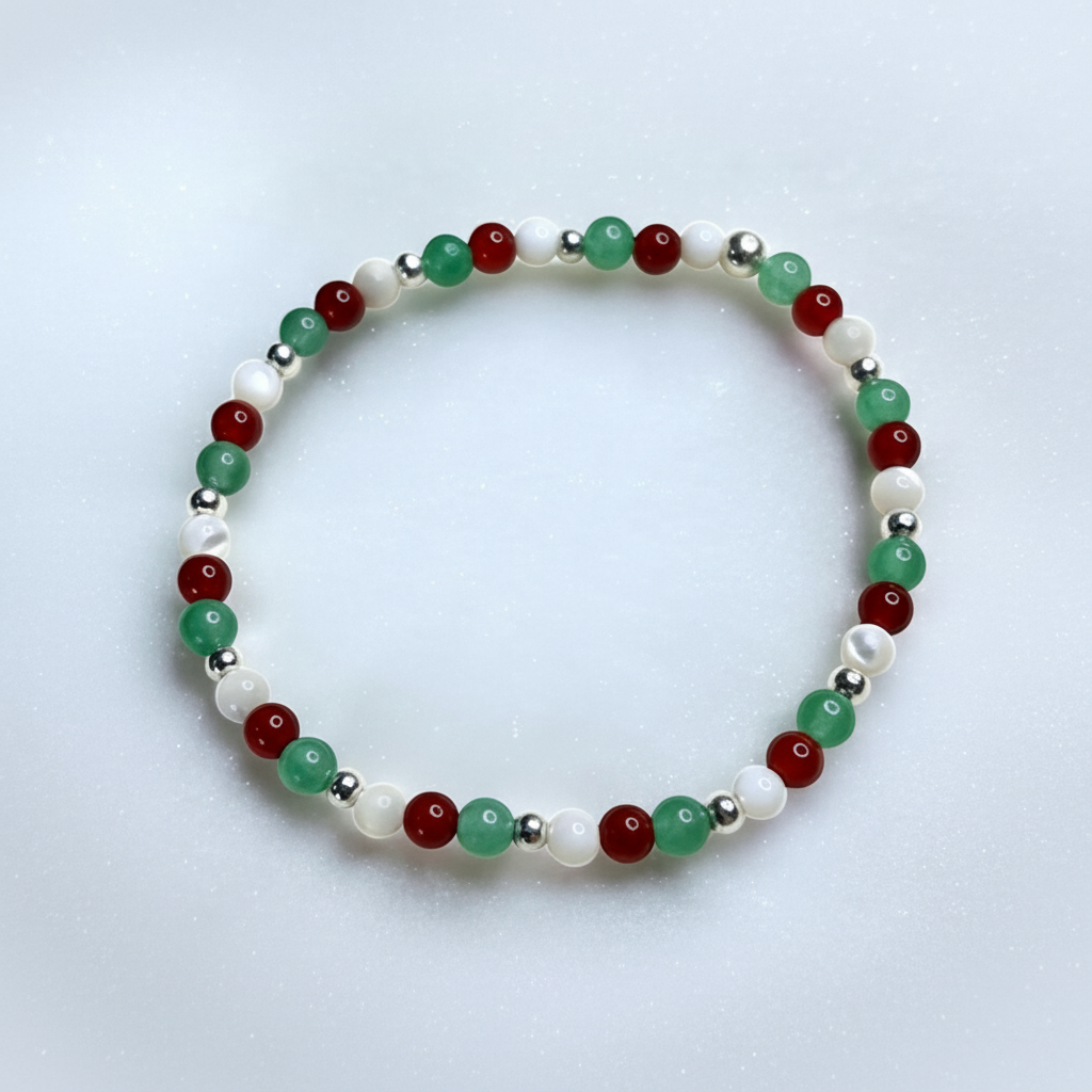 Beaded bracelet with red, green, and silver beads on a light gray background.