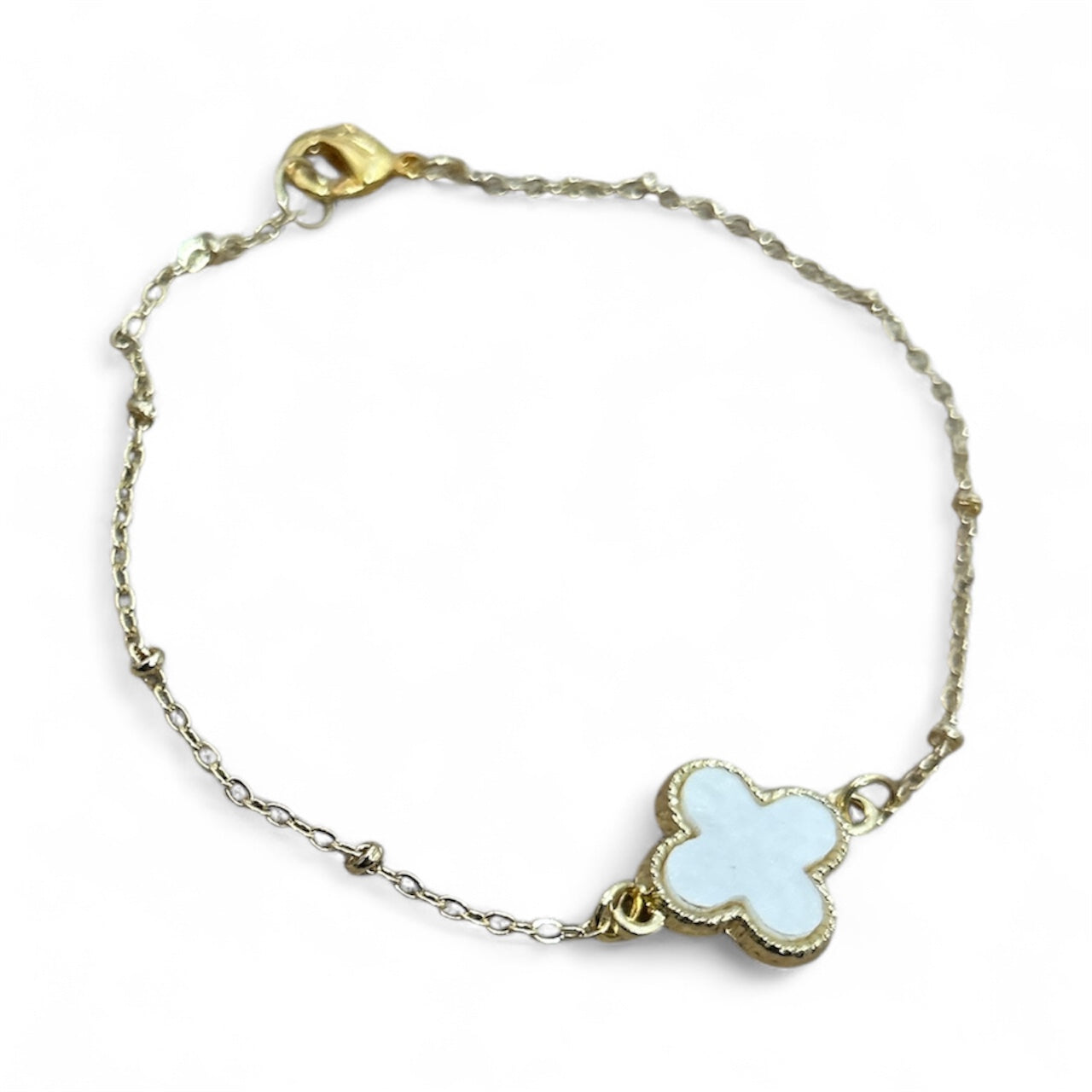 Bracelet with a white clover-shaped charm on a white background