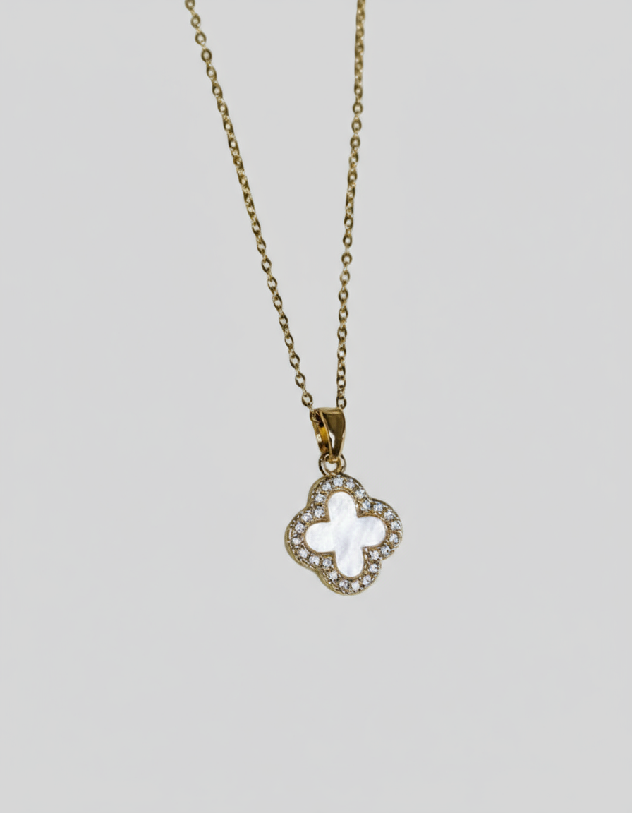 Necklace with a clover-shaped pendant on a light grey background.