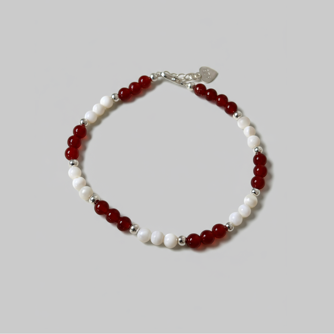 Red and white round polished gemstone beaded bracelet with silver lobster clasp.