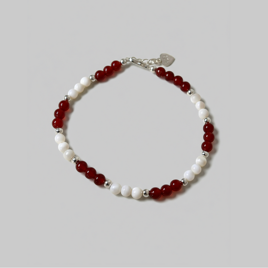 Red and white round polished gemstone beaded bracelet with silver lobster clasp.